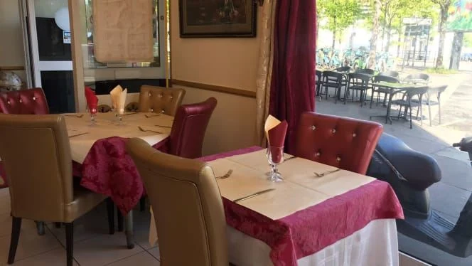Salle du New Mahrajah Grill à Saint-Denis, avec tables dressées et vue sur la terrasse